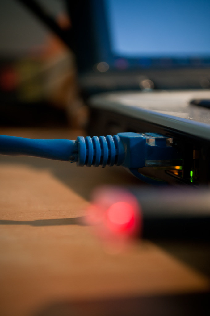 Blue Ethernet cable plugged into a laptop with the link light on