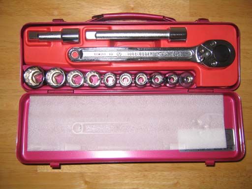 Socket wrench set in an open red metal case: one ratchet handle, two extension bars and ten sockets of different sizes