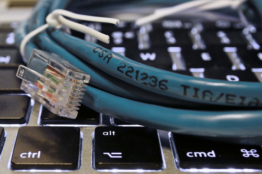 Coiled Ethernet cable resting on a laptop keyboard